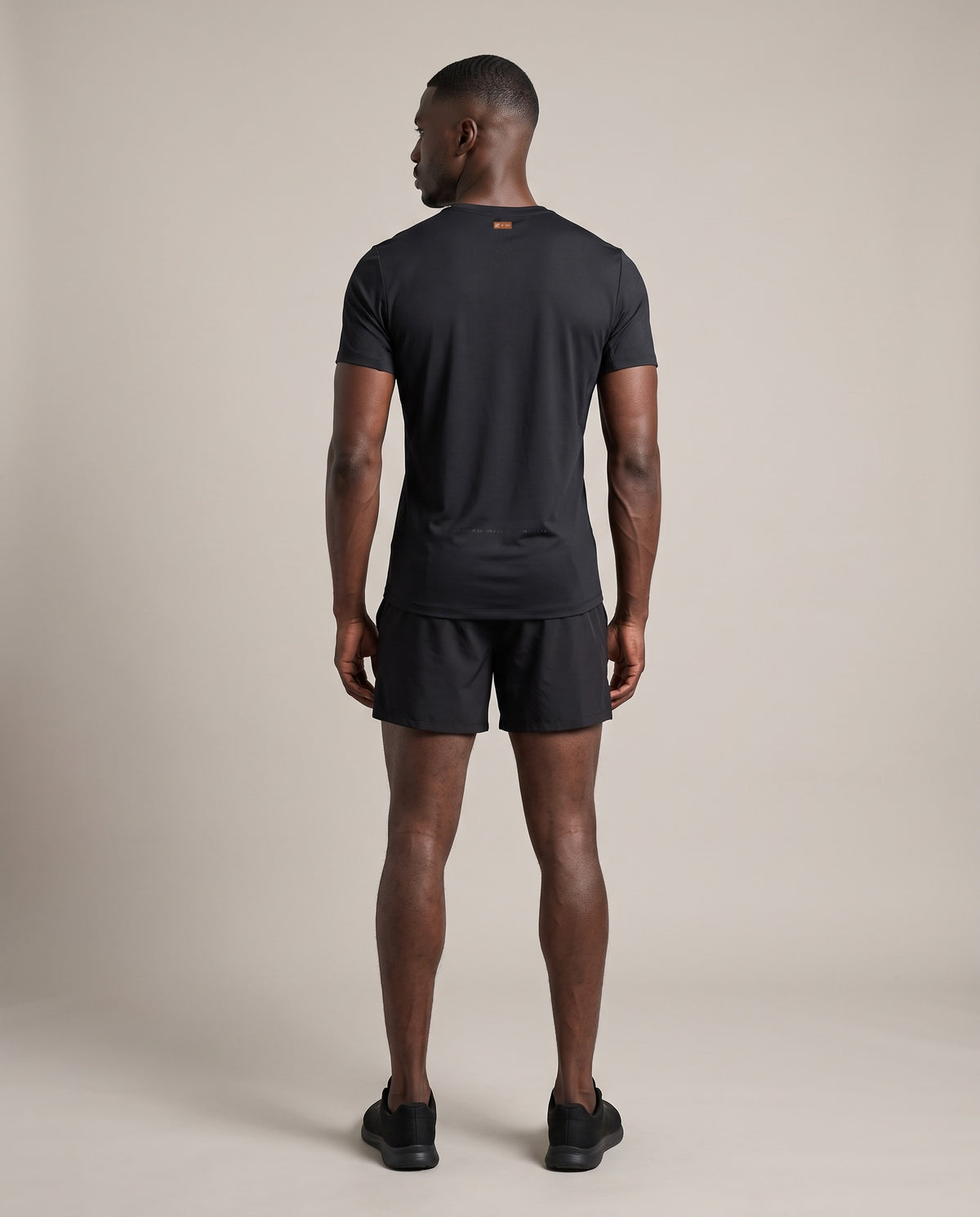 Base Run Tee — Black, back, worn by an ENDUR model