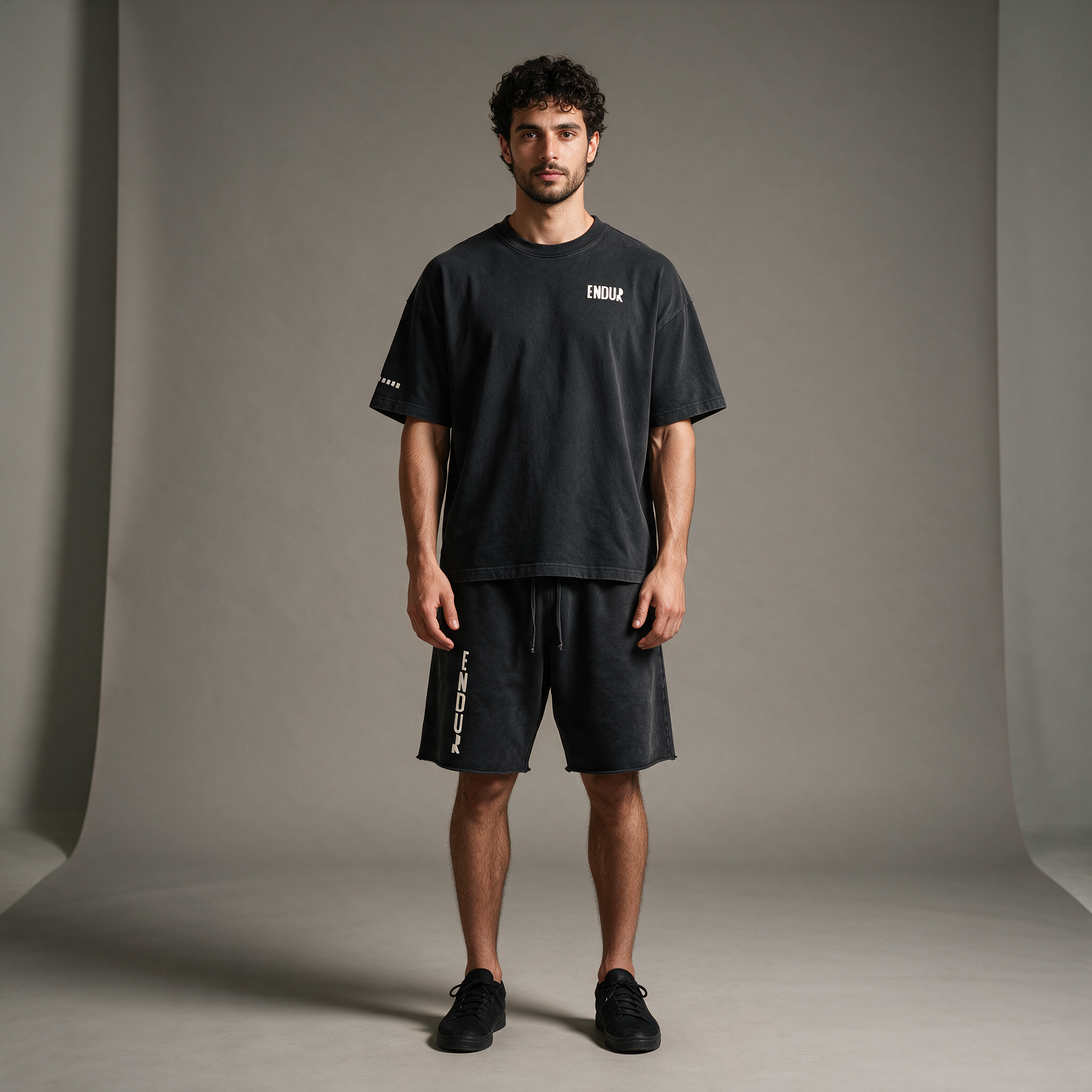 Model wearing the ENDUR Snow Wash Raw Hem Shorts, studio front view