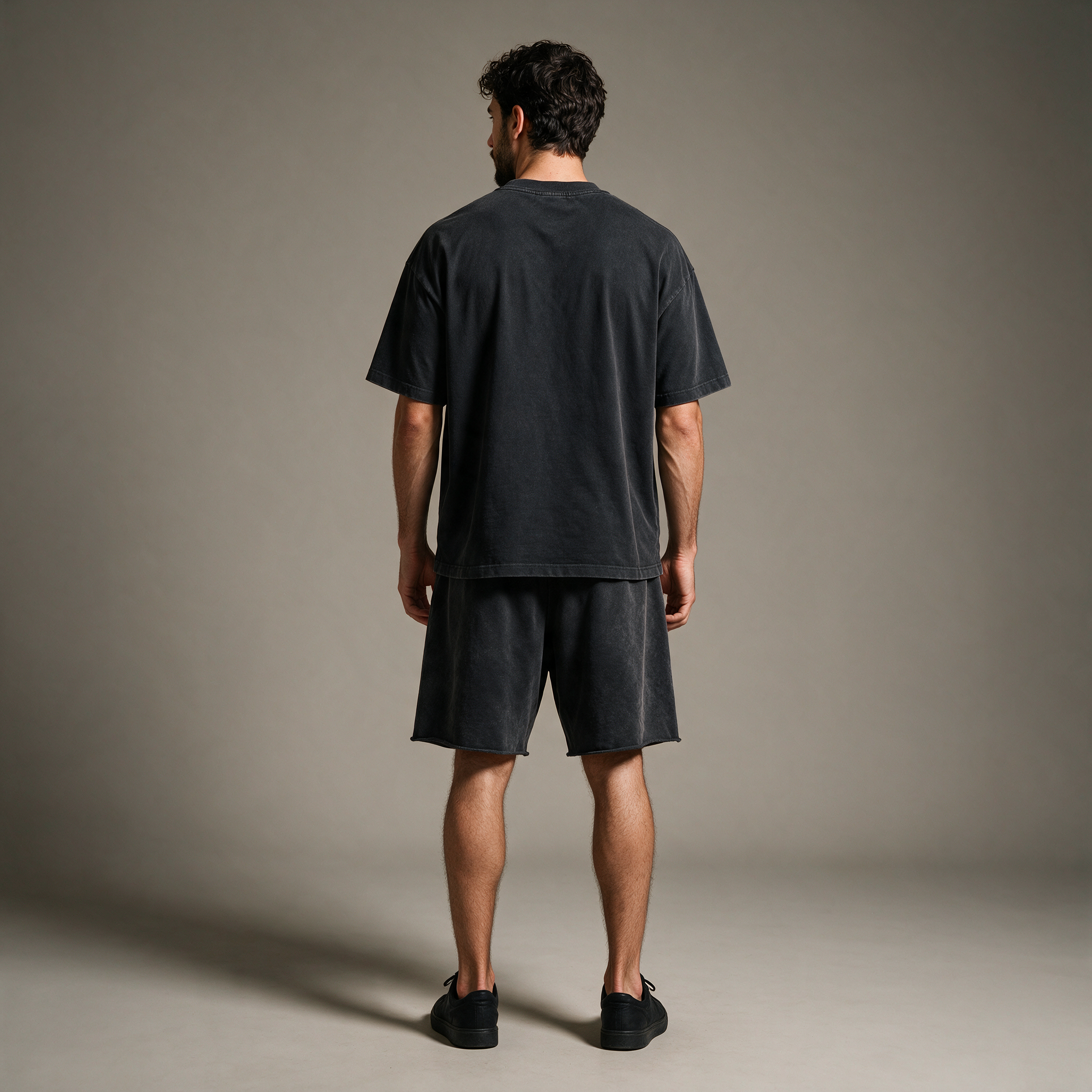 Model wearing the ENDUR Snow Wash Raw Hem Shorts, studio back view