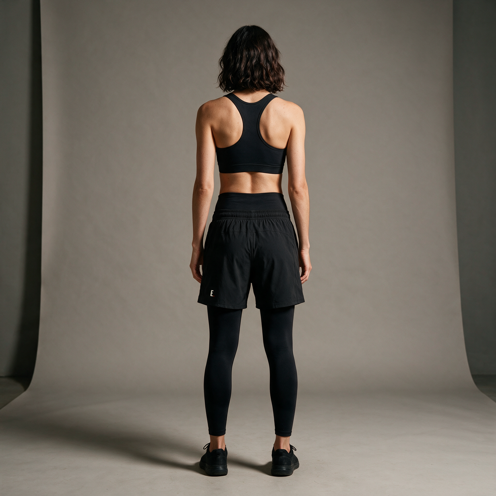 Model wearing the ENDUR Off Day Sports Bra, studio back view